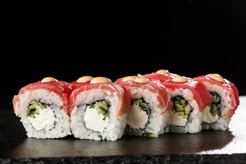 Sushi Rolls with cucumber, tuna, and Cream Cheese inside on black slate isolated. Philadelphia roll sushi with shrimp. Sushi menu. Horizontal photo.