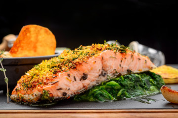 Grilled salmon on cutting board on wooden background