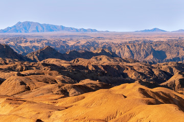 Fototapeta na wymiar Sunrise lights the Yellow Moon valley. Desert Landscape in Africa. Namibia