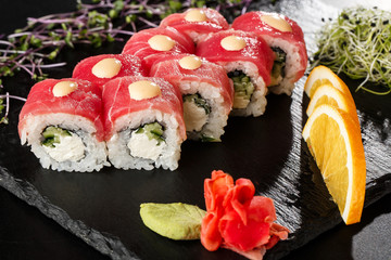 Sushi Rolls with cucumber, tuna, and Cream Cheese inside on black slate isolated. Philadelphia roll sushi with shrimp. Sushi menu. Horizontal photo.