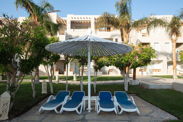 sunshade umbrellas and sunbeds near pool