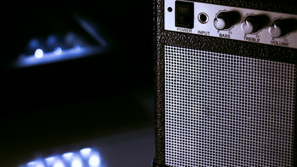 Mini amplificador en primer plano aislado. Luz blanca directa sobre el objeto. Fondo negro.