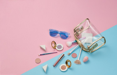 Cosmetic makeup accessories layout. Fashion creative minimal Set. Trendy Design Clutch, lipstick brushes. Art Concept colorful pastel Style. Beauty cosmetic make up tools, fashionable flat lay on blue