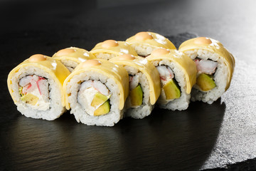 Sushi Rolls with processed cheese, cheddar, american cheese, avocado, crab meat, shrimp and Cream Cheese inside on black slate isolated. Philadelphia roll sushi with shrimp. Sushi menu. Horizontal.
