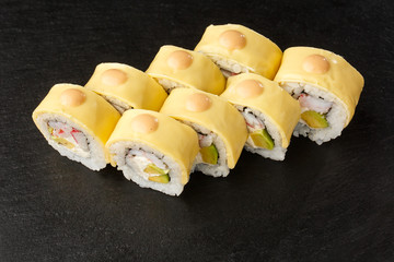 Sushi Rolls with processed cheese, cheddar, american cheese, avocado, crab meat, shrimp and Cream Cheese inside on black slate isolated. Philadelphia roll sushi with shrimp. Sushi menu. Horizontal.