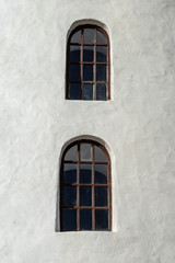 Fototapeta na wymiar Two Windows on an Ancient White Building