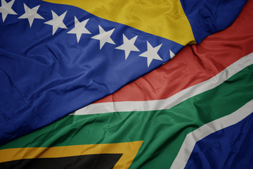 waving colorful flag of south africa and national flag of bosnia and herzegovina.