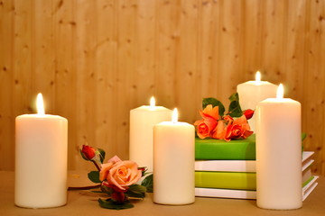 Fototapeta na wymiar Romantic background with candles, books and flowers on a wooden. Picture for the beauty and health industry.