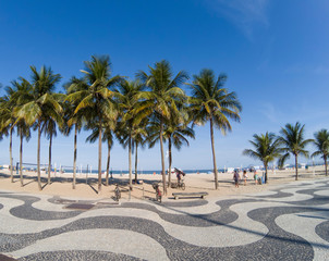 Copacabana Beach - View of famous geometric promenade and coconut trees with blue sky in the background