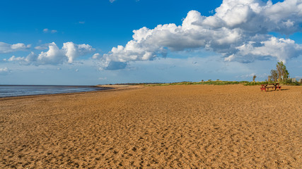 A single picnic bench and table on the empty Heacham South Beach, Norfolk, England, UK