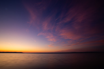 Naklejka premium sunrise over the lake with mellow colors and pink clouds on the sky.
