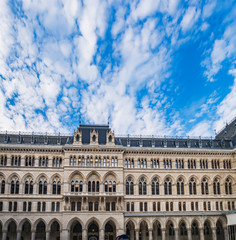 Fototapeta na wymiar Beautiful facade of Town Hall or Rathaus under blue cloudy sky in Vienna, Austria. View from the courtyard