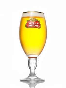 Kiev, Ukraine - August 3, 2017:Cold glass of Stella Artois beer on white background, prominent brand of Anheuser-Busch InBev, is a pilsner brewed in Leuven, Belgium, since 1926