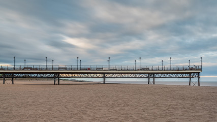 Naklejka premium Clouds over the beach and pier in Skegness, Lincolnshire, England, UK