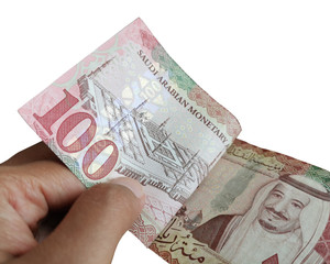 100 Saudi Riyal banknotes in hand isolated on white background