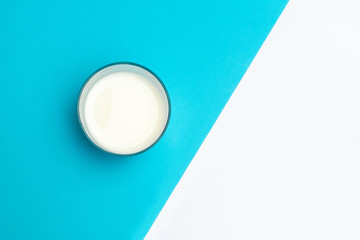 Cup of fermented drink ayran (kefir) on blue and white geometric background
