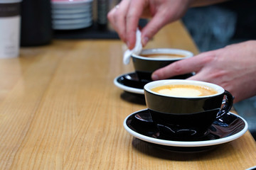 the barista prepared two cups of coffee for the client. selective focus