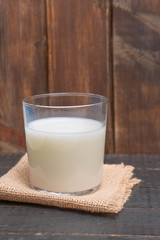 Glass cup of yogurt based drink ayran (kefir) on wooden table.