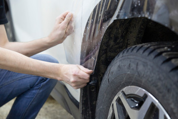 Installation of protective film for car paint.Professional installation of protective film on the car body.