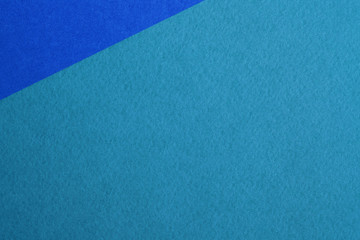 Paper background with paper texture in different colors blue with green superimposed at an angle. Overlaid sheets of paper.