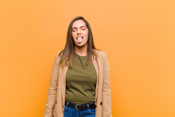 young pretty woman with cheerful, carefree, rebellious attitude, joking and sticking tongue out,...
