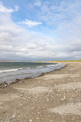 Waves and rocks at Bertra beach in cloudy day