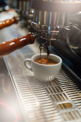 Process of making black coffee from espresso machine, coffee in white cup