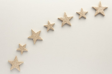 Fototapeta na wymiar Christmas composition. Golden stars top view background with copy space for your text. Flat lay.