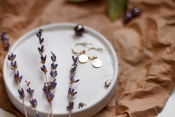 vintage background on Kraft paper with green leaves and dried flowers snake earrings with a glass of water.