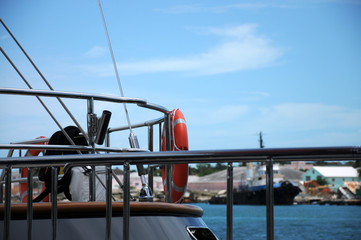 Fishing boat in the harbor. Ropes, fishing equipment. Blue sky.