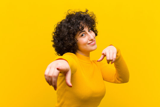 young pretty afro woman feeling happy and confident, pointing to camera with both hands and laughing, choosing you