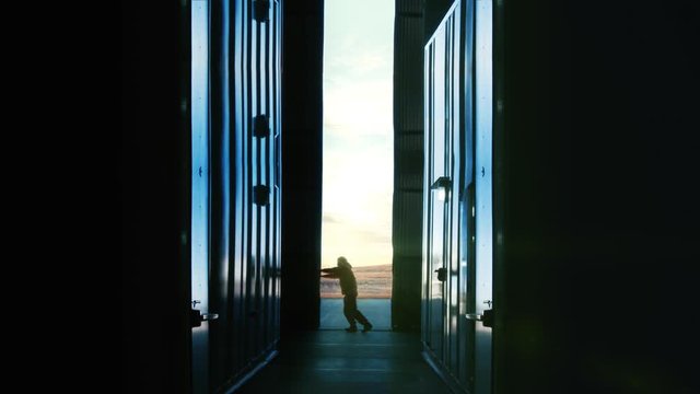Man Opening Door of a Container Warehouse or Hangar at Sunset. 4K resolution.