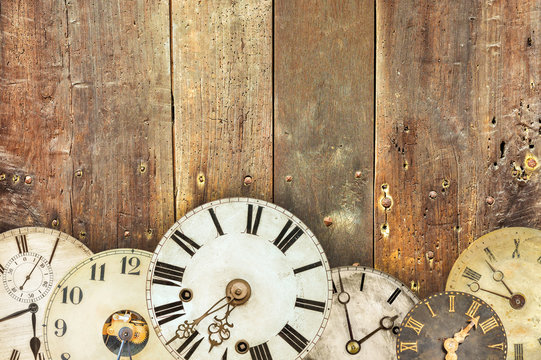 Vintage clocks in front of an old weathered wooden wall