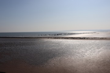Sun reflecting of the wet sand at low tide