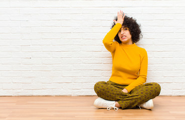 young pretty afro woman raising palm to forehead thinking oops, after making a stupid mistake or...