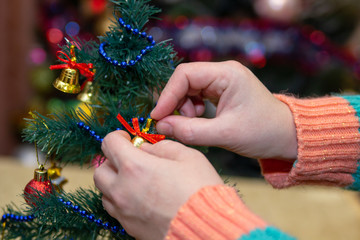 hands decorate the Christmas tree,preparing to celebrate Christmas absorb Christmas tree toys