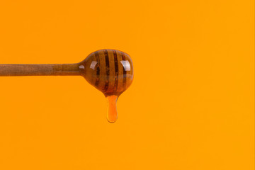 A stick for honey and a small jar, concept on a yellow background.