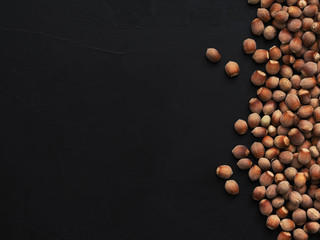 Natural organic hazelnut on a black background. Top view. Healthy eating concept. Natural light. Food background, copy space - photo wallpaper.