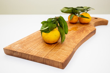 Tangerines ,oranges, mandarins, clementines, citrus fruits, with leaves in basket over rustic wooden background, copy space.Fresh orange mandarine satsuma and tangerine on the gray background ,flat