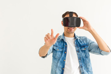 Young man playing games with virtual reality (VR) goggles