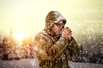 New Year Christmas snowy winter concept Hipster in green coat and hood.Big man with long beard....