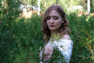 Naklejka premium sad young girl at green bushes background