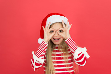 Party fun. Happy kid make glasses gesture red background. Little girl enjoy santa claus party. New Year Eve party. Join us for Christmas party. Celebrate festive season. Holiday celebrations