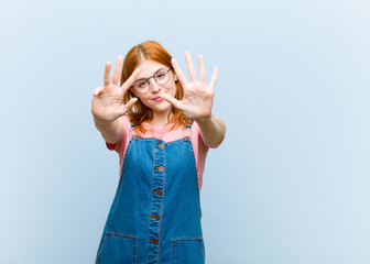 young red head pretty woman smiling and looking friendly, showing number nine or ninth with hand...