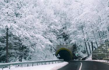 Entrance to the tunnel on a deserted road in the winter during a snowfall.