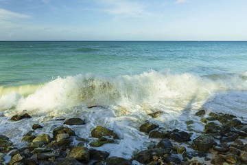 Big wave in Caribbean sea is breaking the coast. Turquoise sea water and blue sky. Great nature background.