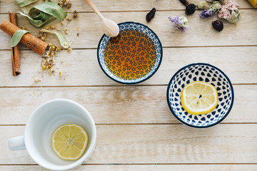 Obraz na płótnie Canvas Autumn hot herbal tea with honey, cinnamon and lemon. Top view. Image toned.