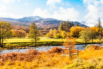 Autumn in Glen Strathfarrar in the Scottish Highlands.  Landscape with snow topped mountains, pine...