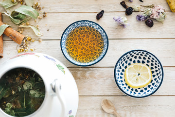 Autumn hot herbal tea with honey, cinnamon and lemon. Top view. Image toned.