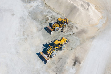 Aerial view of front end loaders at work site. 